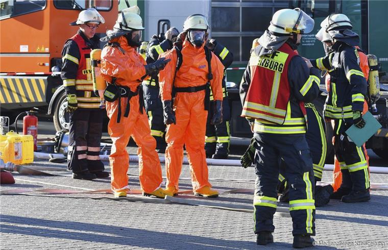 Zum Teil in Schutzkleidung geht die Feuerwehr vor.
