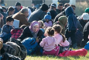 Geflüchtete sitzen auf einer Wiese