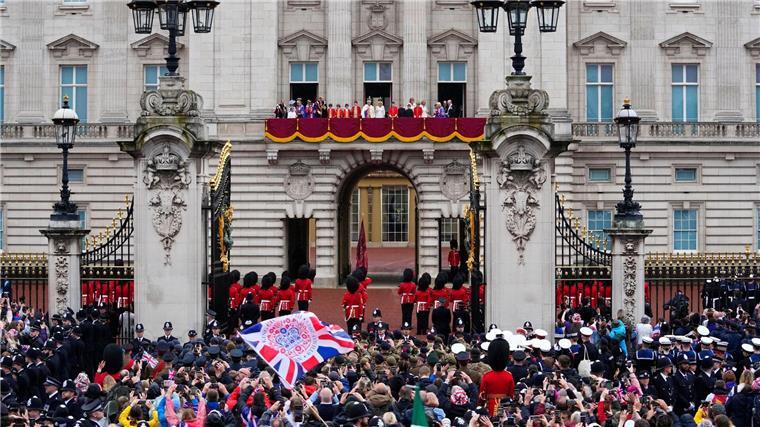 ZUschauer jubeln nach der Krönung von König Charles III. und Königin Camilla vor dem Buckingham Palast in London.