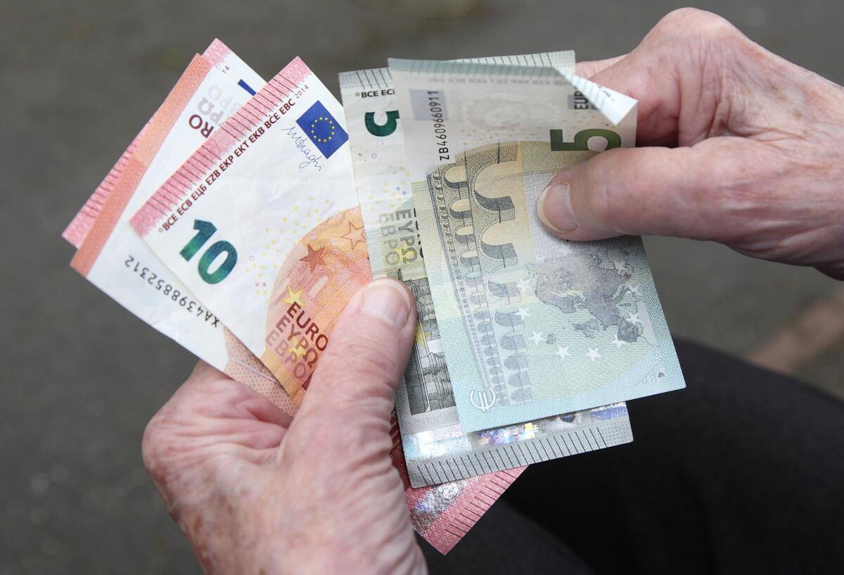 Eine Seniorin haelt Geldscheine in ihrer Hand. Ab 2027 können Bürger unter bestimmten Voraussetzungen zur Rente gezwungen werden.