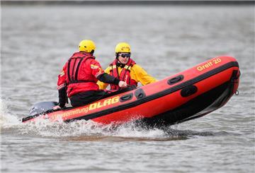 Zwei DLRG-Retter fahren während einer Präsentation mit einem Schlauchboot auf der Elbe.