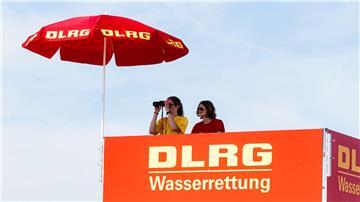 Zwei DLRG-Rettungsschwimmerinnen beobachten von ihrem Hochsitz aus das Treiben am Südstrand von Damp.
