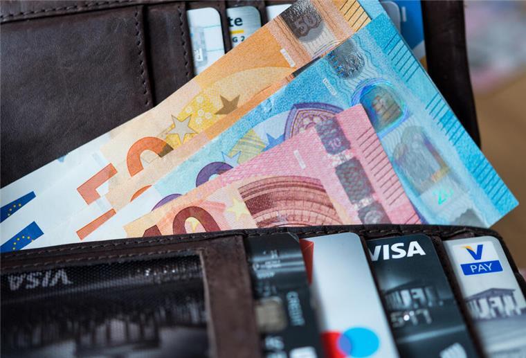 Banknoten und Bankkarten liegen in einer Geldbörse