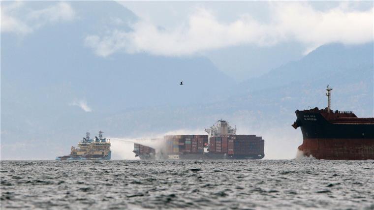 Allianz: Trend zur E-Mobilität erhöht Brandrisiko Zwei kleinere Schiffe löschen ein Feuer an Bord eines Containerschiffes.