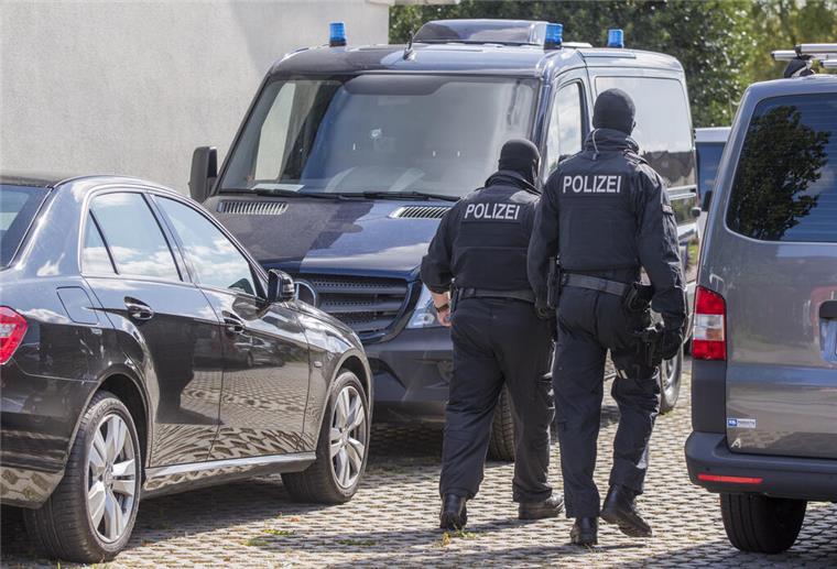 Eine Hand hält Handschellen vor einen Streifenwagen der Polizei. Am 05.04.2022 wird in Berlin die Polizeiliche Kriminalstatistik 2021 vorgestellt. +++ dpa-Bildfunk +++