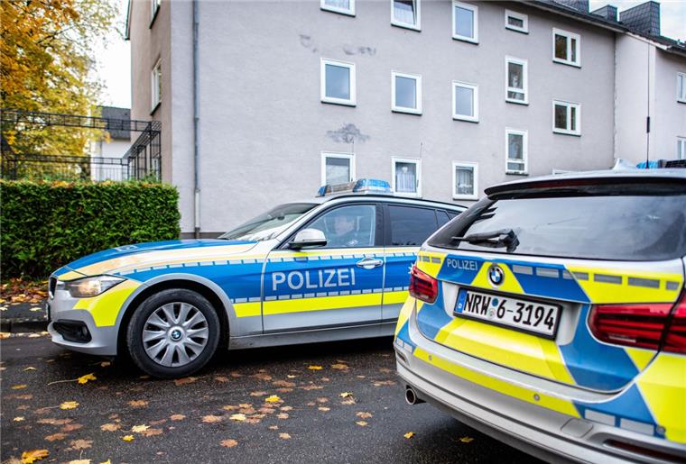 Zwei Polizeifahrzeuge stehen vor dem Mehrfamilienhaus, wo  eine 15-Jährige ihren dreijährigen Halbbruder in Detmold mit einem Messer getötet haben soll.  