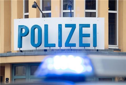 Ein Einsatzwagen der Polizei steht vor einer Dienststelle.