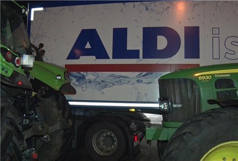 Zwei Traktoren blockieren einen LKW des Lebensmitteldiscounters Aldi. 