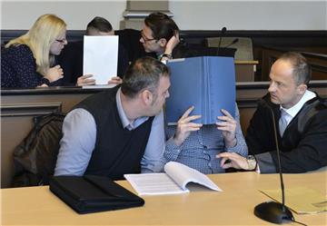 Zwei wegen Mordes angeklagte Männer sitzen im Landgericht Verden neben ihren Anwälten und Dolmetschern. Die Angelagten, die sich Aktendeckel vors Gesicht halten, sollen auf einen 46-Jährigen geschossen haben, der später starb. Blutrache wird als Motiv angenommen. Das Foto entstand zum Prozessauftakt im  November. 