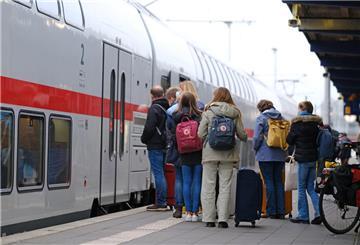 Menschen stehen am Samstagmorgen auf einem Bahnsteig am Bahnhof Norddeich Mole vor einem eingefahrenen Zug. Die Herbstferien in Niedersachsen gehen zu Ende. +++ dpa-Bildfunk +++